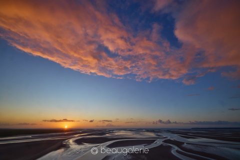 Coucher de soleil sur le parvis du Mont Saint-Michel, reflets sur les sables et nuages roses