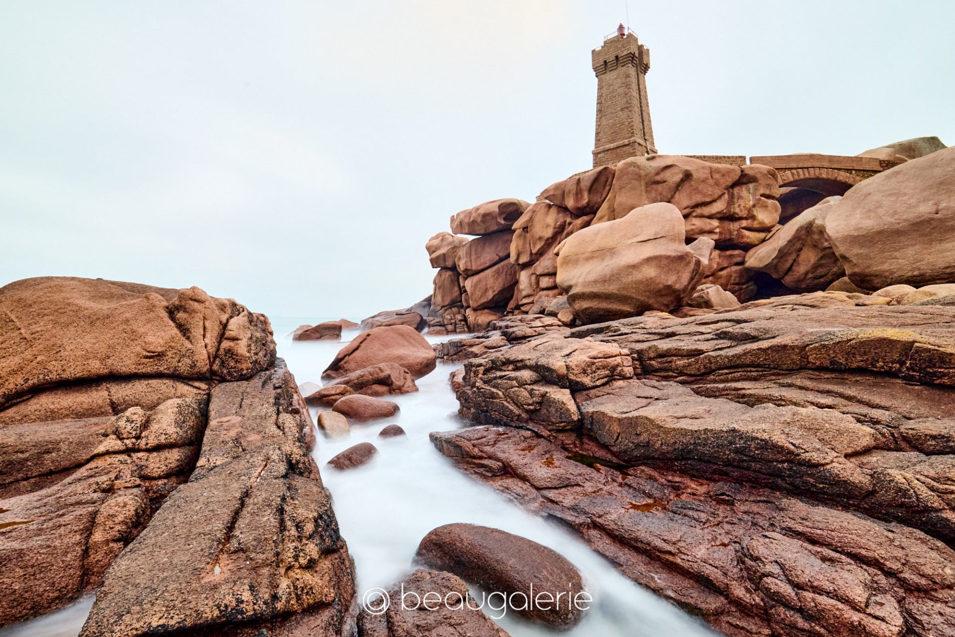 Granit rose sous les nuages Ploumanac'h Bretagne Photographie d'art montrant le granit rose sous les nuages avec le phare de Ploumanac'h en Bretagne.