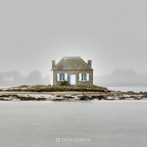 Photographie de la maison Nichtarguér sur son îlot à Saint-Cado par temps de pluie avec volets bleus.