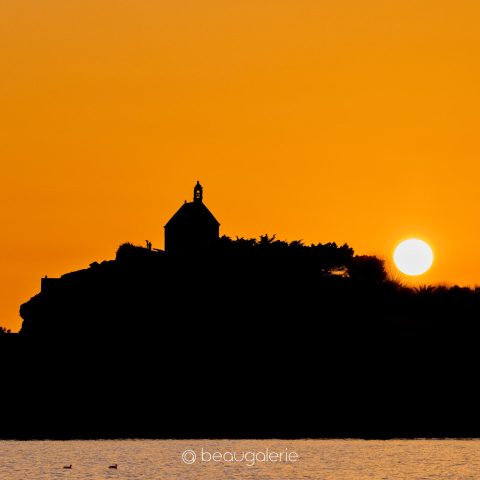 Contre-jour lever soleil chapelle Sainte-Barbe Roscoff, silhouette noire sur ciel orangé, photographie d'art format carré