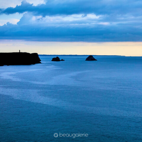 Heure bleue sur la pointe de Pen Hir à Camaret sur Mer, rochers sombres, mer calme et horizon lumineux, photographie d art