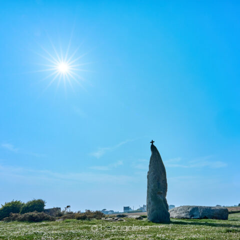 Le menhir de Men Marz sous le soleil éclatant sur un tapis fleuri à Brignogan-Plages
